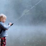 toddler wearing gray hoodie holding fishing rod